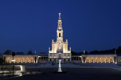 a large building with a clock tower at night at Linda House in Casais de São Mamede