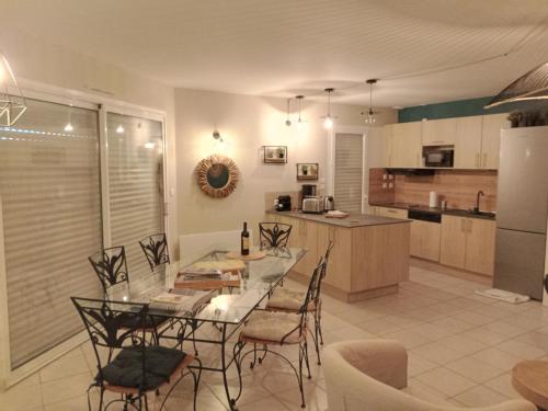 eine Küche und ein Esszimmer mit einem Tisch und Stühlen in der Unterkunft Villa du Golf Eden Parc in Lacanau-Océan