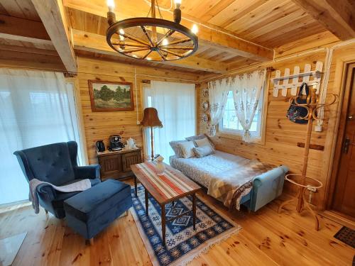 ein Schlafzimmer mit einem Bett, einem Stuhl und einem Kronleuchter in der Unterkunft Domek z bala na Podlasiu z balią ogrodową 