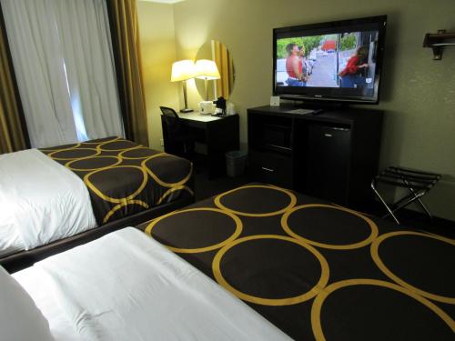 a hotel room with a bed and a flat screen tv at Super 8 by Wyndham New Cumberland in New Cumberland