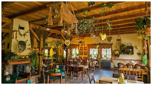 um restaurante com mesas e cadeiras e uma lareira em Kaktusik em Augustów