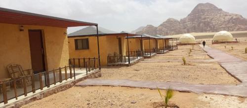 a row of houses with a mountain in the background at Yara camp in Wadi Rum