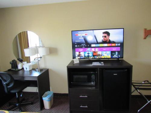 a hotel room with a flat screen tv on a desk at Super 8 by Wyndham New Cumberland in New Cumberland