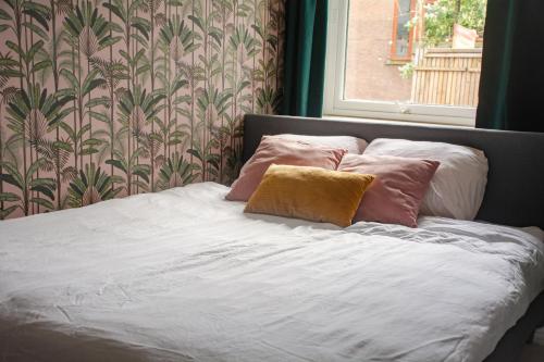 a bed with three pillows on it in a bedroom at Hostel Barbarossa in Nijmegen