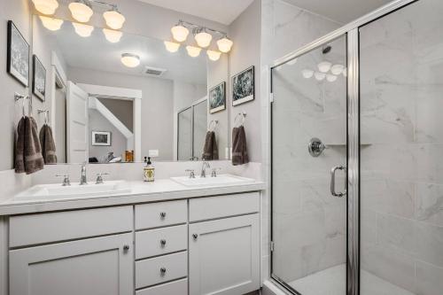 a white bathroom with two sinks and a shower at Waverly Place in Portland