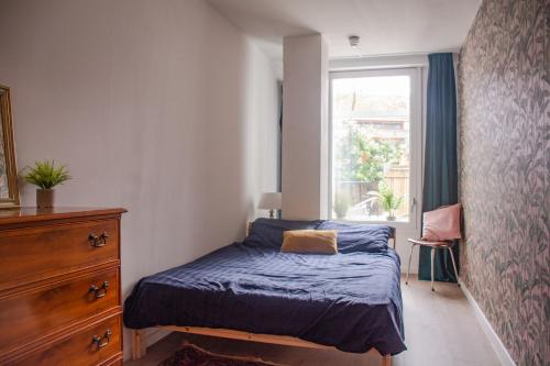 a small bedroom with a bed and a window at Hostel Barbarossa in Nijmegen