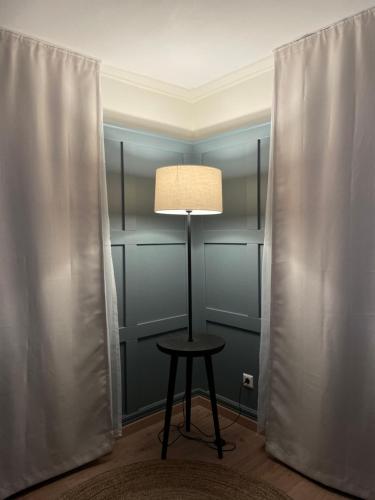 a lamp sitting on a stool in a room with curtains at Altes Rathaus in Schwaigern