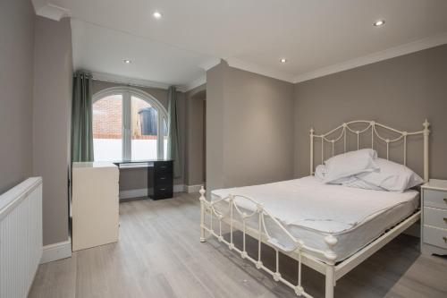 a bedroom with a white bed and a window at Riverside Central Kingston Flat 1B in Surbiton