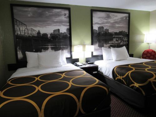 two beds in a hotel room with two large windows at Super 8 by Wyndham New Cumberland in New Cumberland