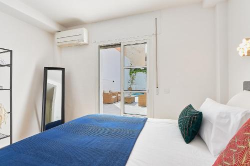 biała sypialnia z łóżkiem i lustrem w obiekcie Pintada Apartment in Nerja by Solaga Holiday Homes w mieście Nerja