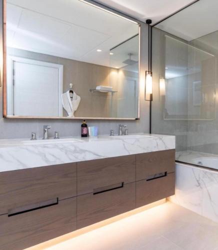 a bathroom with a large sink and a large mirror at Address beach resort fujairah in Ḩaqīl