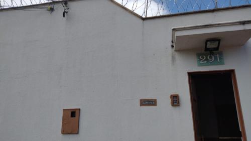 um edifício branco com uma porta e um sinal nele em POUSADA ROSA BRANCA em Uberlândia