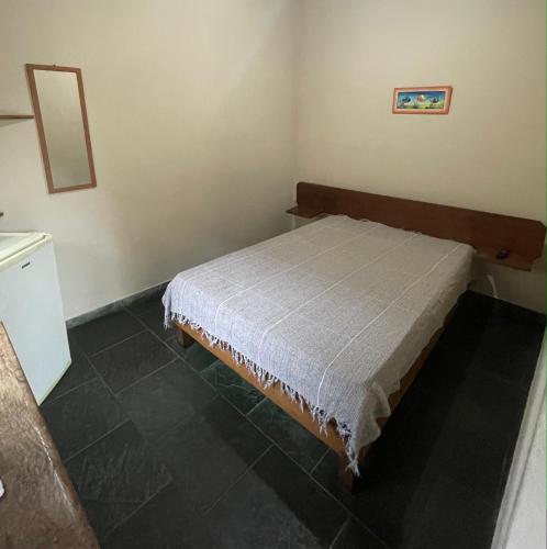 a small bedroom with a bed in a room at Chalés Água de Coco in Boicucanga