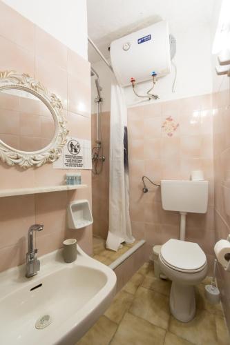 a bathroom with a toilet and a sink and a mirror at Naos Studios - Private Apartment in Kavos