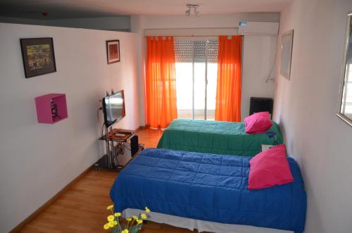 a bedroom with two beds and a television at Apartamento Viajero in Buenos Aires