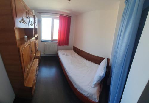 a small bedroom with a bed and a window at Blue Sky Apartament in Constanţa