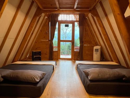two beds in a room with a window at Ciawitali Glamping in Cibitung 2
