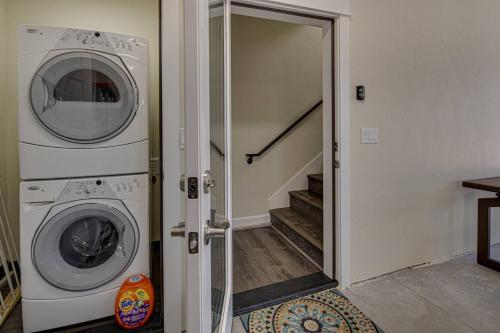 a laundry room with a washer and dryer next to a staircase at Tranquil Charm in Redmond