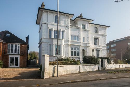 an old white house on the corner of a street at Riverside Central Kingston Flat 1B in Surbiton