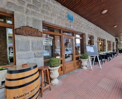 a restaurant with a barrel in front of a building at Hostal Sainz in Riaño
