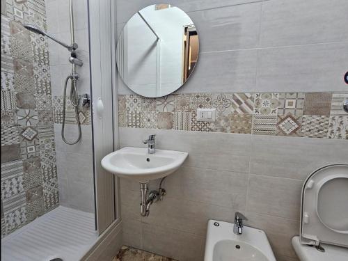 a bathroom with a sink and a toilet and a mirror at B&B dei Rota Affittacamere Mercato San Severino Salerno in Mercato San Severino