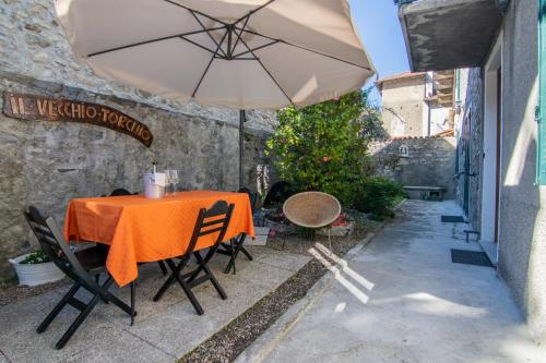 a table with an umbrella on a patio at Il Vecchio Torchio in Perledo