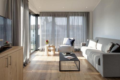 a living room with a white couch and a table at Hotel M120 in Munich