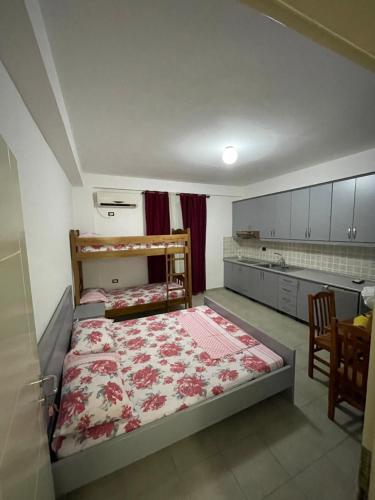 a small bedroom with a bed and a kitchen at Aleksi rooms in Shëngjin