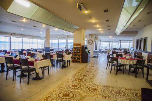 a dining room with tables and chairs and windows at Çanak Hotel in Canakkale