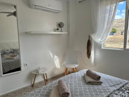 een witte slaapkamer met een bed en een raam bij Casa Blue Lagoon KLIMA FREE WIFI POOL SAT TV in San Miguel de Salinas