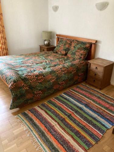 - une chambre avec un lit doté d'une couverture colorée et d'un tapis dans l'établissement Garden Cottage, à Rancon