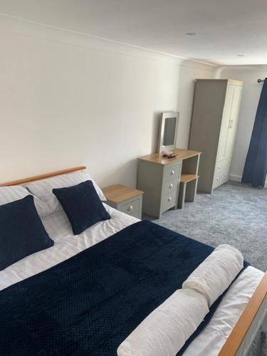 a bedroom with a large bed and a desk at Plum Tree Corner in Chapel Saint Leonards