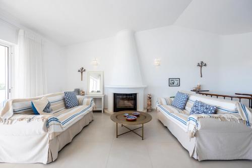 ein Wohnzimmer mit 2 Sofas und einem Kamin in der Unterkunft CoolHouses Algarve Luz, 3 Bed townhouse, lovely sea views, village centre, Casa Limoeiro 54LBC in Luz