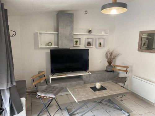 un salon avec une grande télévision à écran plat dans l'établissement Charmante maison avec piscine, à Gourdon