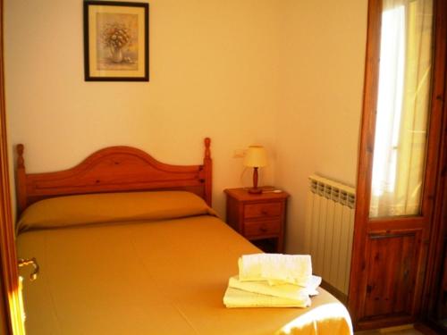 um quarto com uma cama, um candeeiro e uma janela em Casa Rural López Ordesa em Frajén