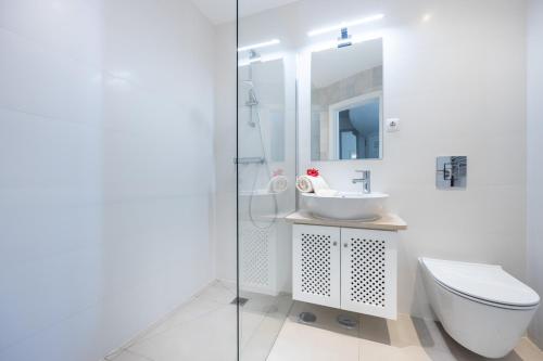 ein weißes Bad mit einem WC und einem Waschbecken in der Unterkunft CoolHouses Algarve Luz, 3 Bed townhouse, lovely sea views, village centre, Casa Limoeiro 54LBC in Luz