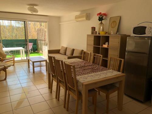 eine Küche und ein Esszimmer mit einem Tisch und einem Kühlschrank in der Unterkunft Lucie in Hyères