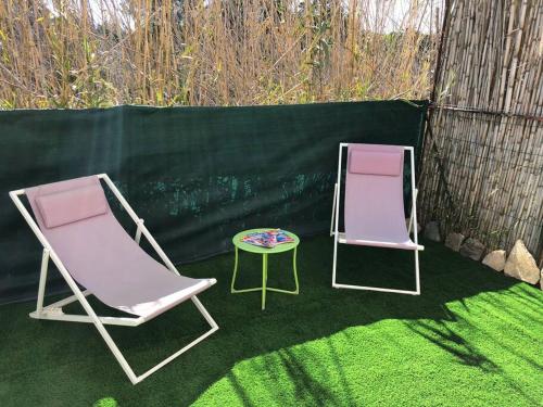 2 Gartenstühle und ein Tisch auf einem Hof in der Unterkunft Lucie in Hyères