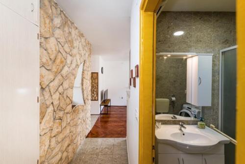 a bathroom with a sink and a stone wall at IL MURO apartment in Zadar