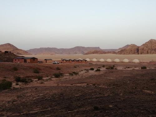 a desert with a group of domes in the distance at Yara camp in Wadi Rum