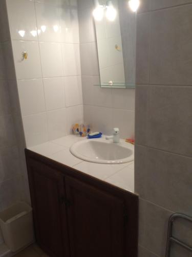 een badkamer met een wastafel en een spiegel bij Casa Minana in Propriano