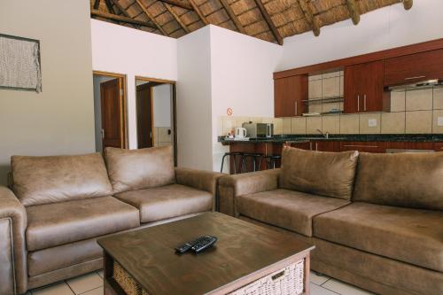 a living room with two couches and a coffee table at Kruger View Chalets in Malelane
