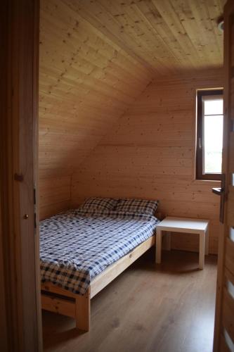 a bed in a log cabin with a window at Marco in Sarbinowo
