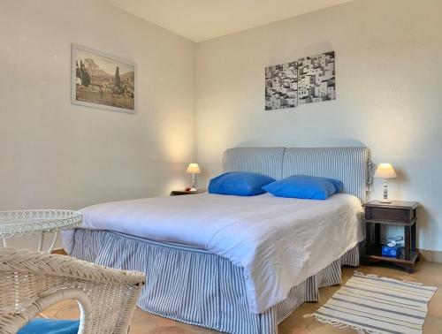 een slaapkamer met een groot bed met blauwe kussens bij bastide derroc in Cotignac