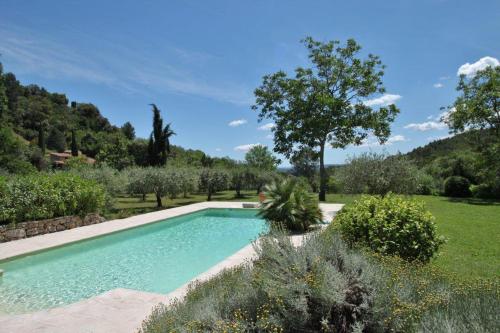 a swimming pool in the middle of a garden at bastide derroc in Cotignac