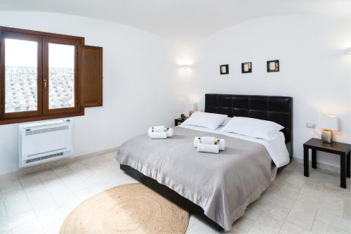 una camera da letto con un letto con due asciugamani sopra di Domo Mea Terra e Domo Mea Chelu - Comfort nel centro storico di Orosei a Orosei