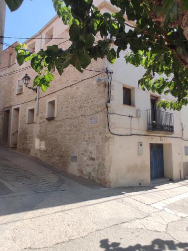 a stone building with a door and a balcony at Casa Vall Bona in Pobla de Masaluca