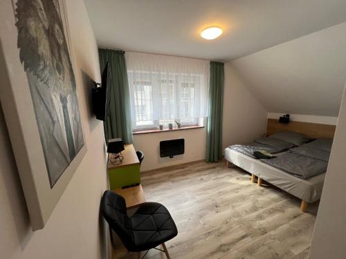 een kleine slaapkamer met een bed en een raam bij Pod Gromadzyniem Resort in Ustrzyki Dolne