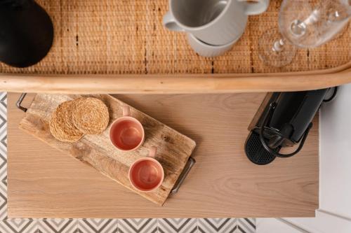 a wooden table with two cups on a cutting board at Margaret Luxury Suites in Naxos Chora