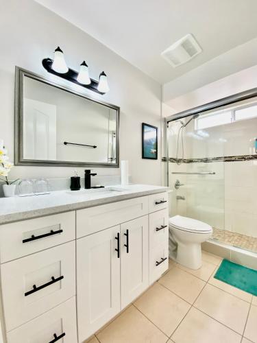 a bathroom with a sink and a toilet and a mirror at Burnaby Metrotown Cozy 3 Bedroom Suite in Burnaby